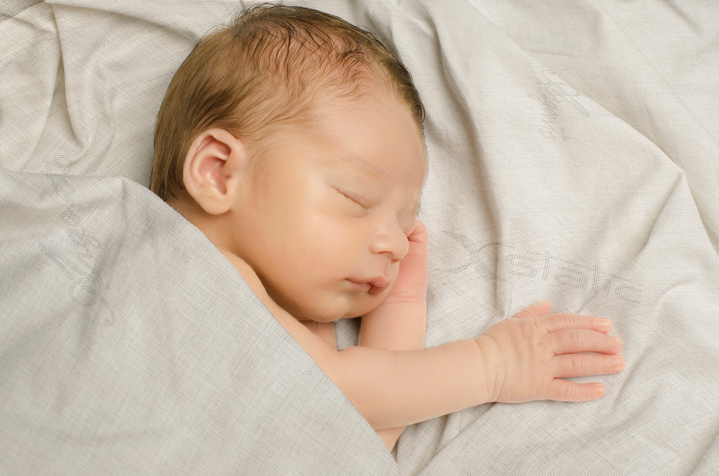 Baby sleeping protected by Silverpro baby sheet set